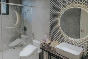 a bathroom with a toilet and a sink and a mirror at Chungi Hotel 純吉民宿 咖啡 in Xincheng +6 photos