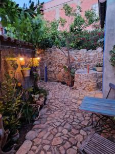 a stone pathway in a garden with a blue bench at Casa Olive in San Vito