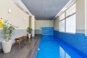 a swimming pool in a building with blue tiles at Bay View Villas in Hobart