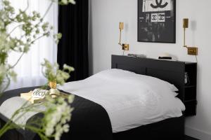 a bedroom with a white bed with a black headboard at Villa COCO Chanel Kamer in Noordwijk