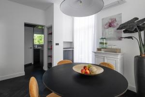 a black dining room table with a bowl of fruit on it at Villa COCO Chanel Kamer in Noordwijk