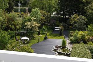 a wooden walkway with a table and chairs in a garden at Villa COCO Chanel Kamer in Noordwijk