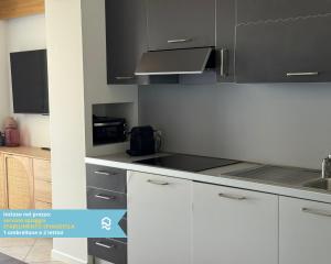 a kitchen with white cabinets and a stove top oven at Sogni blu in Numana +26 photos