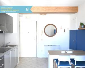 a kitchen with a table with chairs and a mirror at Sogni blu in Numana
