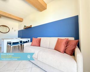 a living room with a white couch and a blue wall at Sogni blu in Numana