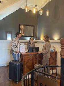 Hotel Boutique Casa Vander في فالبارايسو: مجموعة من الأشخاص يقفون عند مكتب ومعهم أمتعة +26 صورة