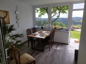 a dining room with a table and a large window at Ferienwohnungen Christa Grabmeier in Grainet
