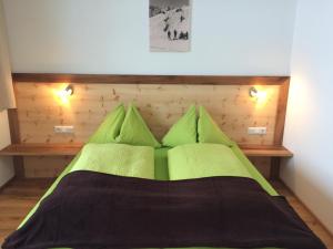 Schlafzimmer mit einem grünen Bett mit einem Kopfteil aus Holz in der Unterkunft Stadtalm Islitzer in Mittersill