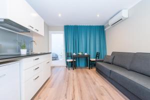 a kitchen and living room with a couch and a table at Senator Barcelona Apartments in Barcelona +64 photos