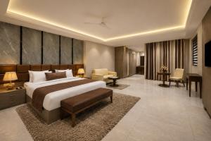 a bedroom with a large bed and a living room at Hotel The Luxury Delhi Airport in New Delhi +82 photos