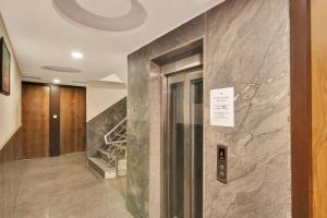 a elevator in a building with a marble wall at Hotel O Avi Suites in New Delhi