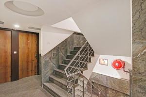 a staircase in a house with a stone wall at Hotel O Avi Suites in New Delhi