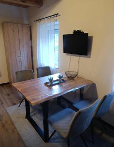 a dining room table with chairs and a flat screen tv at Ferienwohnung Storck in Bad Bleiberg