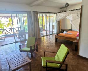 a bedroom with a bed and two chairs and a table at Hotel Arc En Ciel in Dzamandzar
