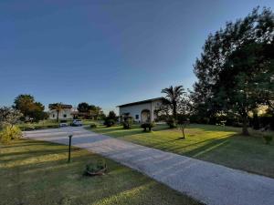 a house with a road in the middle of a yard at Casale Country Chic- Sabaudia in Borgo Isonzo