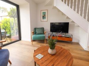 a living room with a table and a tv at Snowdrop Cottage in Morpeth