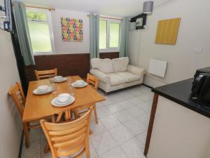 a kitchen and dining room with a table and chairs at Cabin No 16 - Salt and Fern Cabins in Port Talbot