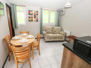 a living room with a table and chairs and a couch at Cabin No 15 - Salt and Fern Cabins in Port Talbot
