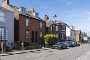 a street with cars parked in front of brick houses at Ace Cottage in Lymington