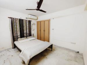 a bedroom with a bed and a ceiling fan at Ravuri's Residency in Hyderabad