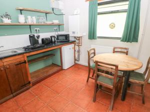 a kitchen with a table and a small table and chairs at Cabin No 11 - Salt and Fern Cabins in Port Talbot +20 photos
