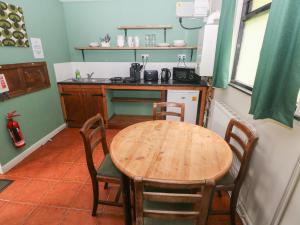 a kitchen with a wooden table and chairs in it at Cabin No 11 - Salt and Fern Cabins in Port Talbot