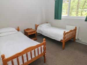 two twin beds in a room with a window at Cabin No 11 - Salt and Fern Cabins in Port Talbot