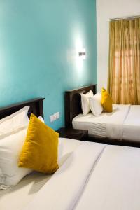 a hotel room with two beds with yellow pillows at Heavens Gate Ella in Ella