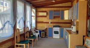 a kitchen with blue cabinets and chairs in a room at Duży kemping in Ustronie Morskie