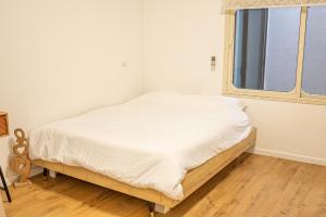 a white bed in a room with a window at Cozy peak suite in Majdal Shams