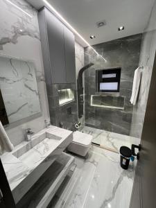 a bathroom with a sink and a toilet and a shower at Hodoon Apartments in Amman
