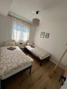 a bedroom with two beds and a window at Marta Apartment in Čitluk