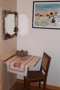 uma mesa e uma cadeira com uma mesa e um espelho em Kèbele em Roana