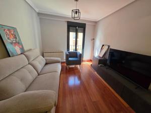 a living room with a couch and a flat screen tv at Sweet Dreams Úbedas in Talavera de la Reina