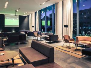 a lobby with couches and tables and a tv at Mercure Nador Rif in Nador
