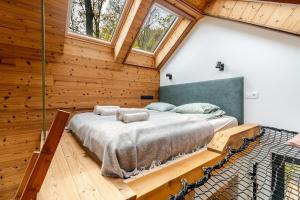 a bedroom with a large bed in a room with wooden walls at Merengő lombház in Nagymaros