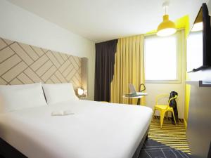 a hotel room with a large white bed and a window at Ibis Styles Paris Massena Olympiades in Paris