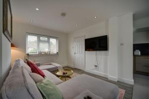 a living room with a couch and a tv at The Chislehurst Hideaway in Chislehurst
