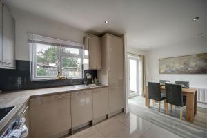 a kitchen with white cabinets and a table and chairs at The Chislehurst Hideaway in Chislehurst +24 photos