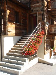 una escalera con flores en el lateral de un edificio en Armonia Livigno Appartamenti, en Livigno