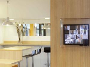 a kitchen with a counter with a tv on the wall at hotelF1 Nancy Sud in Houdemont +32 photos