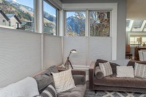 a living room with two couches and large windows at East Side Hideaway in Telluride