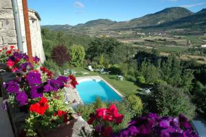 a view from a balcony with flowers and a swimming pool at La Clavelière in Saint-Auban-sur-Ouvèze