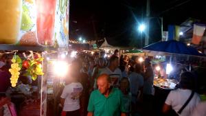 a crowd of people standing in a market at night at Baan Pitcha บ้านพิชชา in Lamai