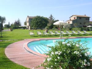 a swimming pool with chaise lounge chairs in a yard at Agriturismo I Pagliai in Cortona