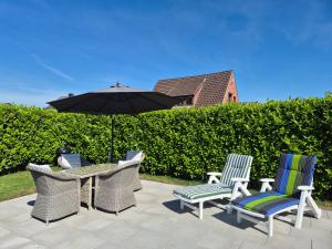 a patio with a table and chairs and an umbrella at Ferienwohnung Haus Fischer in Langwedel