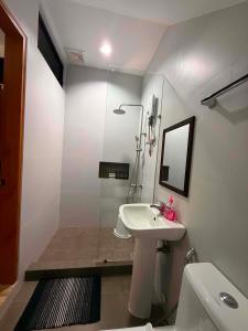 a white bathroom with a sink and a mirror at Villa Dietze in Davao City +8 photos