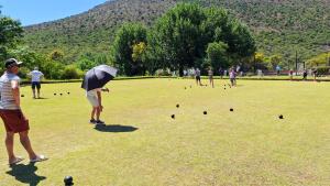 a group of people standing in a field with an umbrella at Blanco Guest Farm - Holiday Resort in Tarkastad