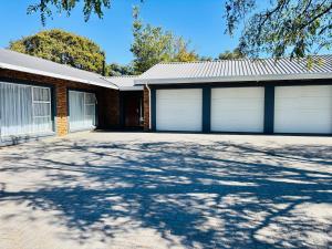 a house with two garage doors and a driveway at Homestead in Kempton Park
