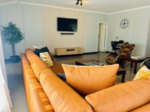 a living room with a couch and a tv at Homestead in Kempton Park
